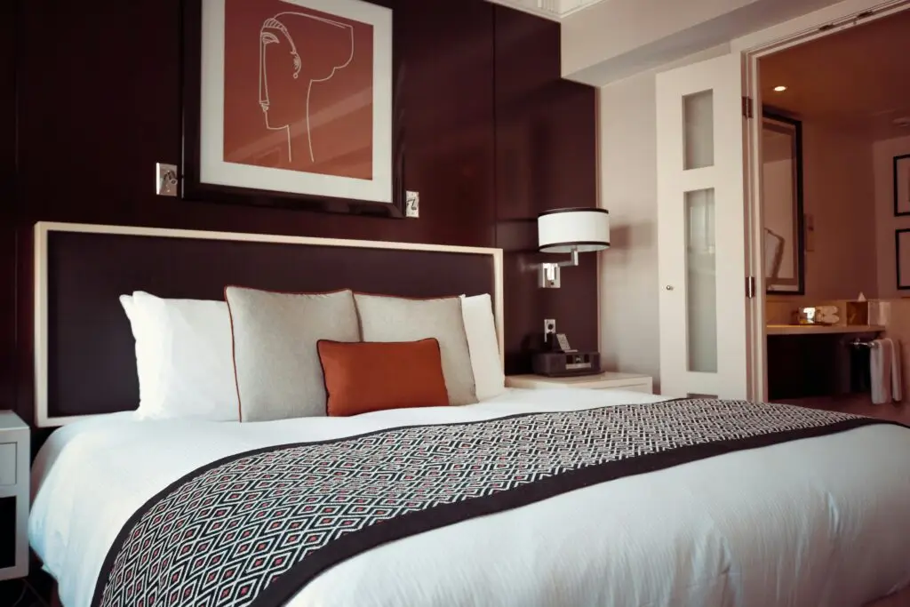Bedrijfsafval Cozy and modern hotel bedroom interior with elegant decor and soft lighting.